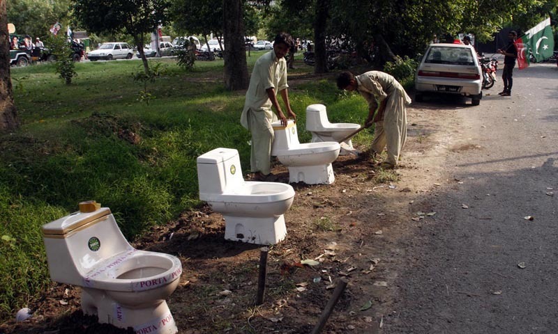 Workers in Lahore install commodes for the participants of the Azadi March near the residence of PTI chairman Imran Khan — INP PHOTO