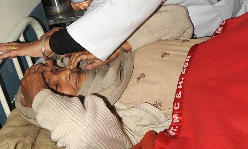 An Indian medical personel puts drops into the eye of patient Sampuran Kaur, who lost sight in her eye after undergoing surgery at an eye camp, at a government hospital in Amritsar on December 5, 2014.  — AFP