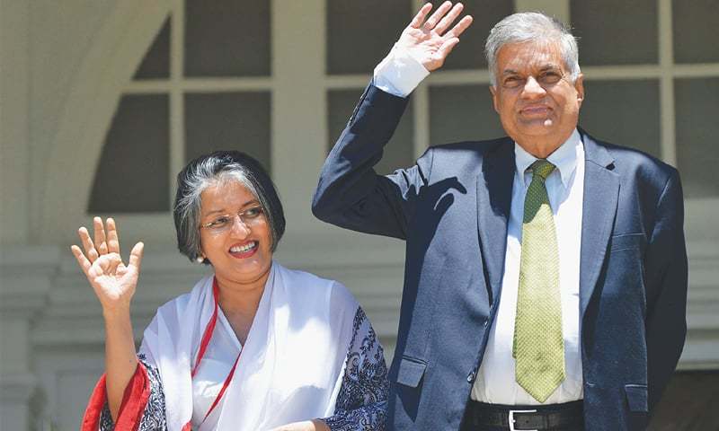 SRI LANKAN Prime Minister-elect Ranil Wickremesinghe and his wife Maithree wave to the media at their Temple Trees residence in Colombo on Wednesday.—AFP