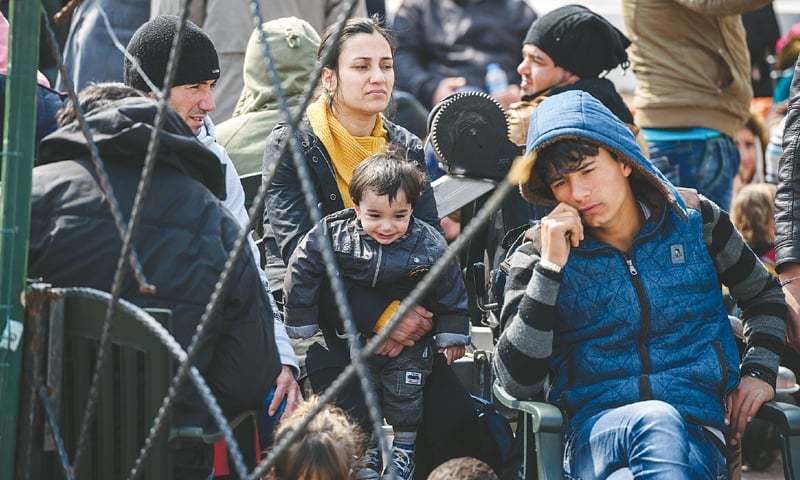 Izmir: Migrants wait at a Turkish coast guard station here on Sunday.—AFP