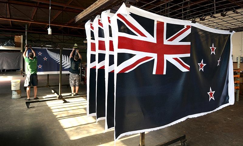 Factory workers Garth Price (L) and Andrew Smith (R) hang new designs of the national flag of New Zealand at a factory in Auckland.─Reuters/File