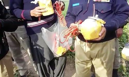 Security personnel display the explosive device defused in Phando area of Peshawar. — Photo by author