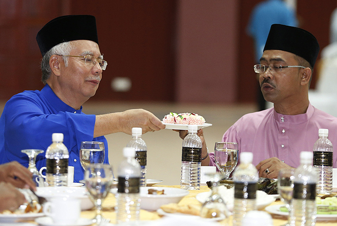 Malaysia's Prime Minister Najib Razak (L) passes a plate of food to opponent Fariz Musa of the People's Justice Party after submitting their nomination papers to contest in Pekan constituency for the upcoming general elections in Pekan, 300 km east of Kuala Lumpur. Malaysia will hold general elections on May 5 in what could be the toughest test of his ruling coalition's 56-year grip on power in Southeast Asia's third-largest economy.—Photo by Reuters