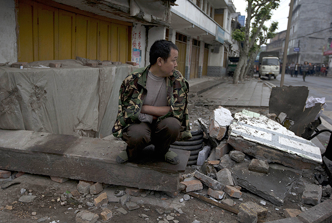 A man sits on a piece of rubble while waiting for food to be distributed in the quake hit county of Lushan in southwestern China's Sichuan province. Saturday's earthquake in Sichuan province killed at least 186 people, injured more than 11,000 and left nearly two dozen missing, mostly in the rural communities around Ya'an city, along the same seismic fault where a devastating quake to the north killed more than 90,000 people in Sichuan and neighboring areas five years ago in one of China's worst natural disasters.—