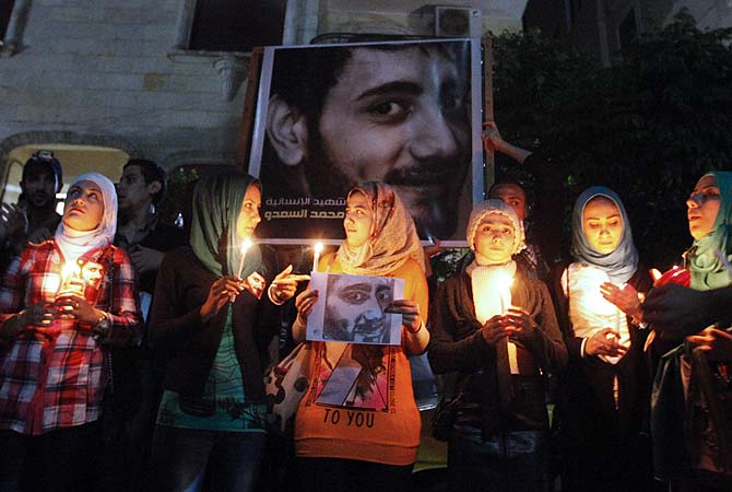 Activists and friends hold candles and a picture of Mohamed al-Saado, who was shot earlier this week by what activists said were unknown assailants, during his funeral in Raqqa province east of Syria, May 16, 2013. Mohamed al-Saado used to work in a medical aid unit, accompanying Free Syrian Army fighters in their military operations.—Photo by Reuters