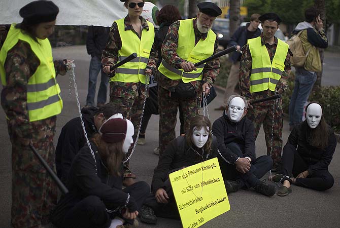 Activists stage a protest in front of the venue of commodities trader Glencore Xstrata's shareholders meeting in the Swiss town of Zug.—Photo by Reuters
