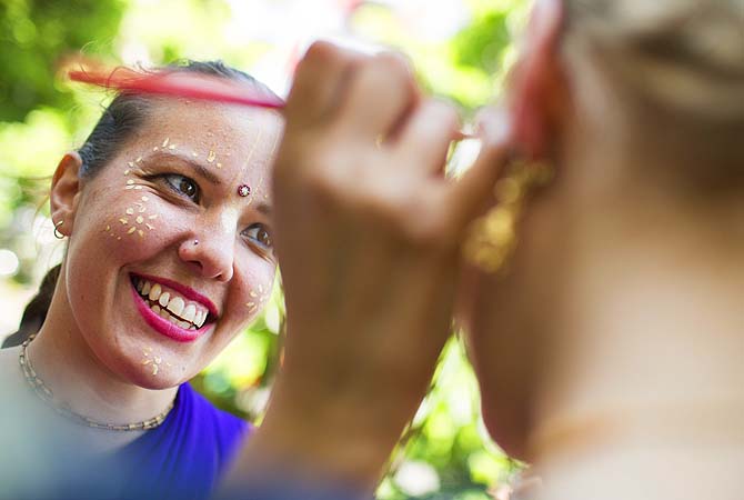 A dancer does the make-up for another reveler prior to the start of the Carnival Of Cultures parade in Berlin, Germany.—Photo by AP