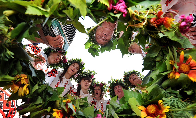 Belarussian women wearing traditional clothes and holding flowers sing in the village of Plastok, some 175 kms south of Minsk, as part of festivities surrounding the Orthodox "Trinity's Day" holiday.—Photo by AFP