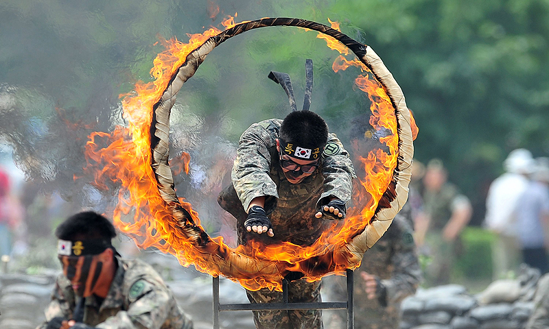 A South Korean soldier jumps through a flaming ring as others perform martial arts during a ceremony for a re-enactment of the battle of Chuncheon at the beginning of the 1950-53 Korean War, to mark its 63th anniversary in Chuncheon, South Korea. The Korean peninsula is the world's last Cold War frontier as Stalinist North Korea and pro-Western South Korea have been technically at war since the 1950-53 conflict.—Photo by AFP