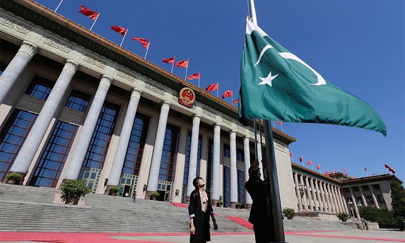 A Pakistan flag is raised aloft outside the Great Hall of the People in Beijing — Reuters