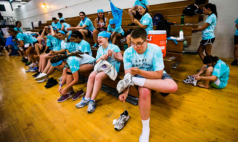 Nicholas Walker ties his shoes after participating in judo at Camp Abilities in Brockport, New York.