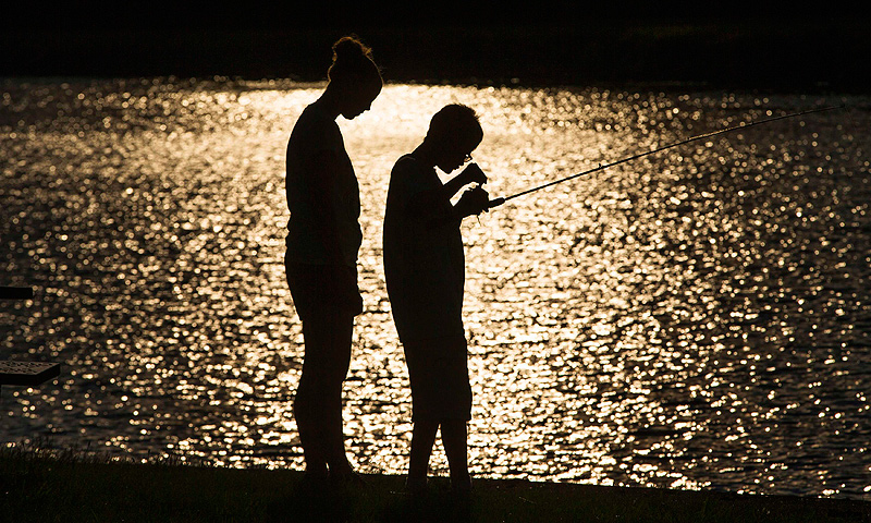 A child fishes with his counselor at Camp Abilities in Brockport, New York.