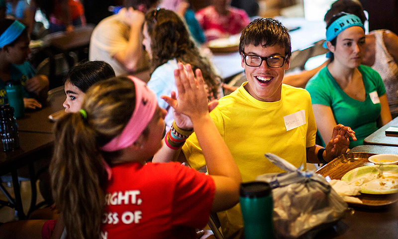 Jordan Vieira high-fives a counselor at Camp Abilities in Brockport, New York.