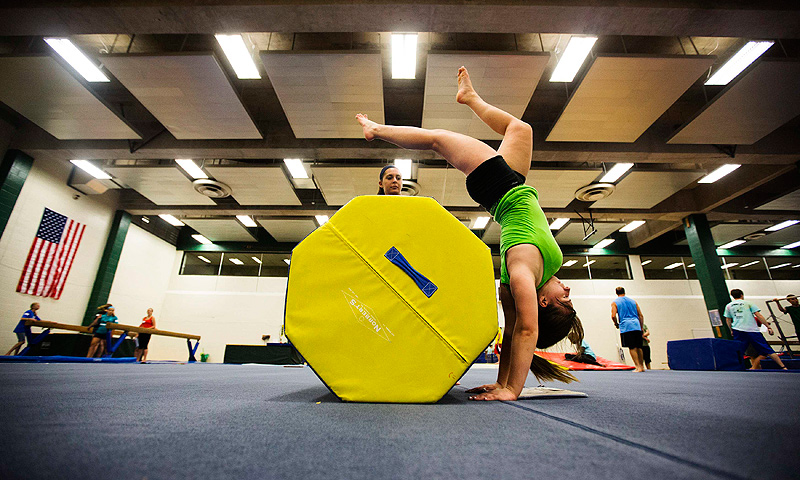 Meghan Fink (R) takes part in gymnastics with her counselor Gabriella Badalucco (C) at Camp Abilities in Brockport, New York.