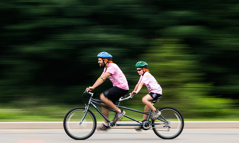 Andrew Mead-Colegrove rides on a tandem bicycle with his counselor Jeffrey Hart (L) at Camp Abilities in Brockport, New York.