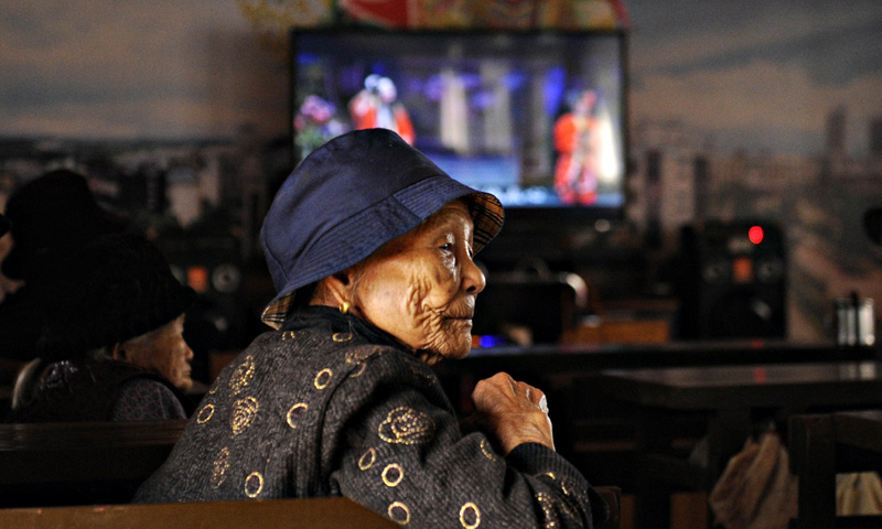 An elderly woman looking on at a tea house in Chengmai city.