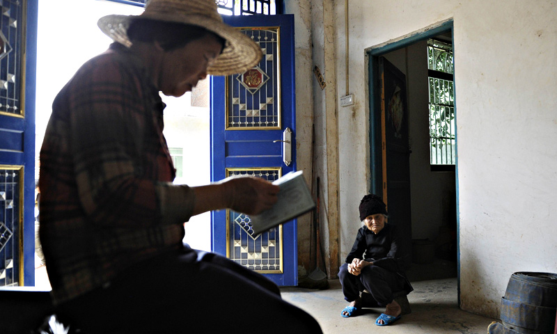 Xu Yuhe, one hundred and three -year - old elderly woman ,having a rest as her daughter-in-law checks her birth certificate in Chengmai city.