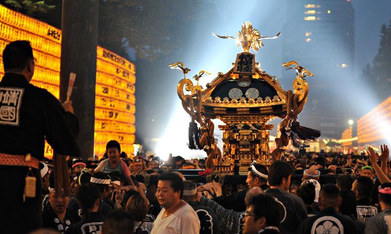 A portable shrine is carried amongst rows of lit lanterns during the Mitama Matsuri festival at the Yasukuni. — AFP Photo