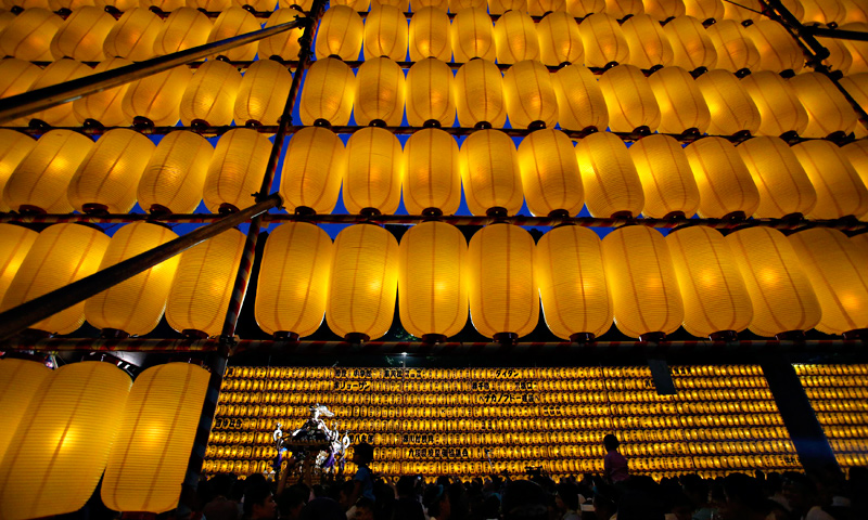 People carry a portable shrine among paper lanterns during the Mitama Festival at the Yasukuni Shrine in Tokyo, July 13, 2013.