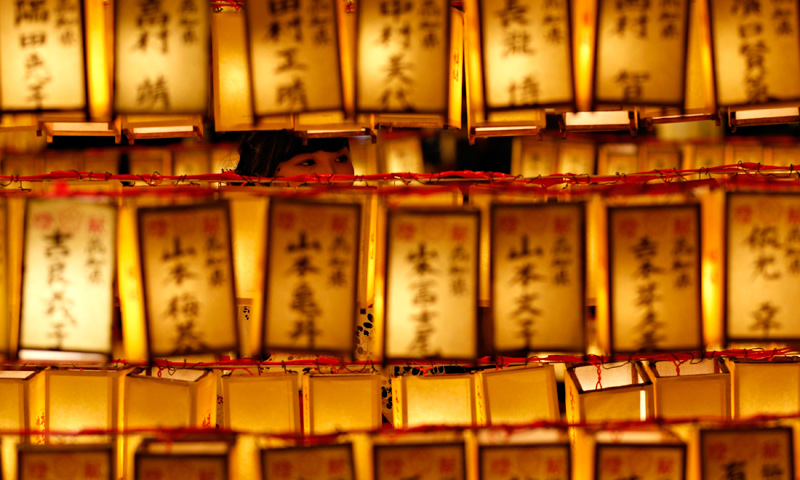 A woman looks at paper lanterns during the Mitama Festival at the Yasukuni Shrine in Tokyo, July 13, 2013.