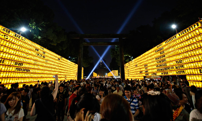 People walk among paper lanterns during the Mitama Festival at the Yasukuni Shrine in Tokyo, July 13, 2013.
