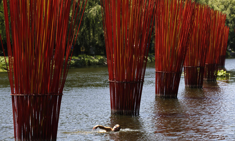 A man swims in a polluted canal in Beijing. The temperature in Beijing rose to 34 degrees Celsius on Tuesday—Photo by Reuters
