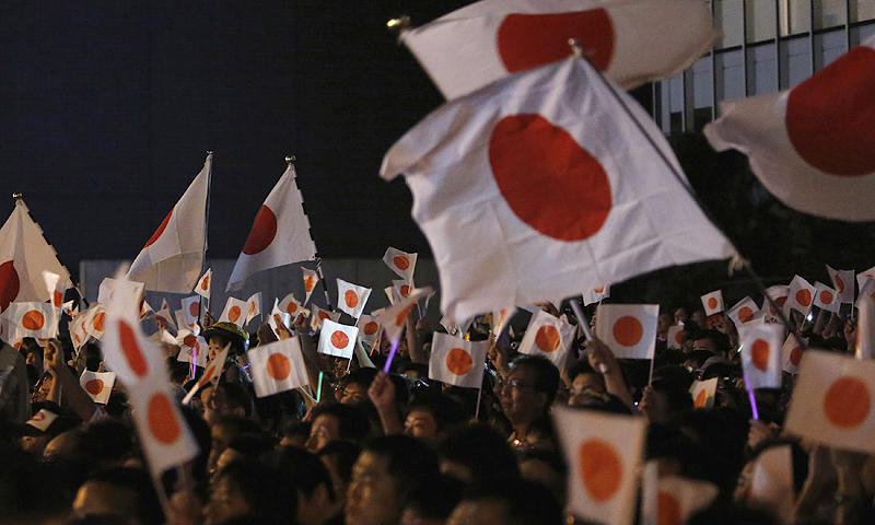 People wave Japanese national flags as Japan's Prime Minister Shinzo Abe (not pictured) and leader of the ruling Liberal Democratic Party (LDP) speaks to voters while campaigning for the July 21 Upper house election in Tokyo. The dollar slipped against the yen in late trade on Friday ahead of elections for Japan's upper house Sunday which could add momentum to Abe's aggressive push for monetary easing to lift growth and fight deflation.—Photo by Reuters