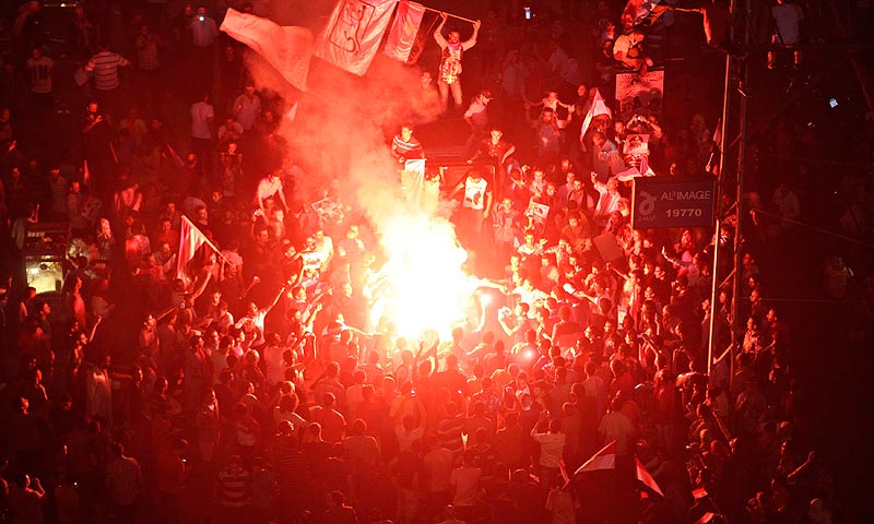 Protesters cheer and dance with flares as they gather for a mass protest to support the army in front of the presidential palace. — Reuters Photo