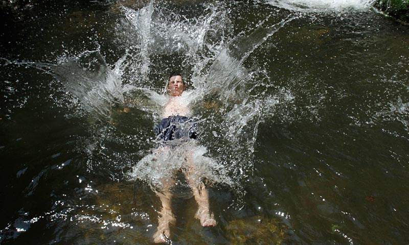 Bosnian dives into a creek to cool down during heat wave near Sarajevo with temperatures exceeding 40 Celsius, 104 Fahrenheit. — AP Photo