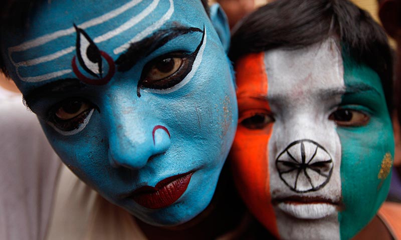 An Indian boy, left, painted with a face of Hindu God Shiva and the other with an Indian flag participate in a walk carrying water from the River Ganges to offer at the Vishwanath Temple in Varanasi. — AP Photo