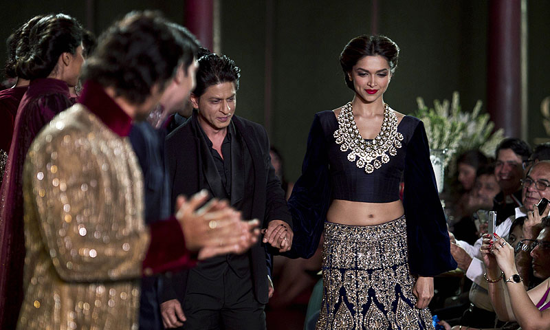 Actors Sharuk Khan second left and Deepika Padukone walk on the ramp to displays Indian designer Manish Malhotra's creations, during the Delhi Couture Week in New Delhi, India.—Photo by AP