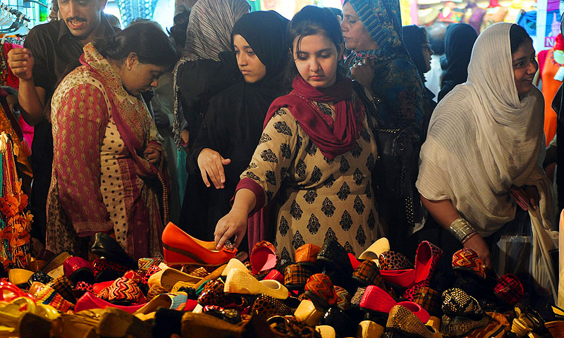 Women shopping for shoes at a market ahead of the Muslim festivities of Eidul Fitr, in Karachi.—Photo by AFP