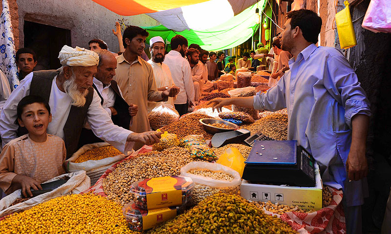Men buy dry fruits and sweets for the Eid festival, which marks the end of the Muslim holy month of Ramadan, at a market in Afghanistan.—Photo by AFP