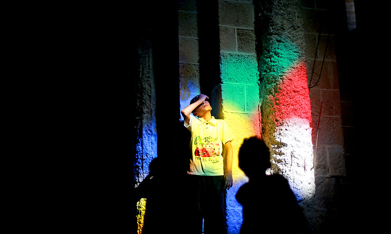 Bands of coloured light stream through reflecting on the wall of a mosque as a boy looks up at a stained glass window, in Gaza City.—Photo by AFP