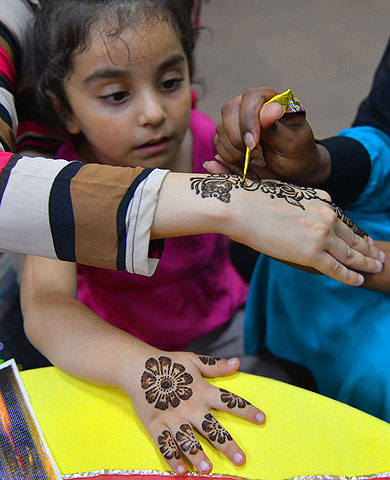 A beautician applies traditional henna designs to the hand of a customer ahead of the festivities of Eidul Fitr in Islamabad.—Photo by AFP