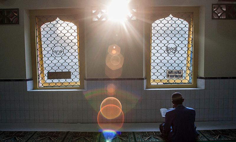 An Indonesian man reads Quran as he waits for the time to break his fast at a mosque in Solo, Central Java. — AP Photo