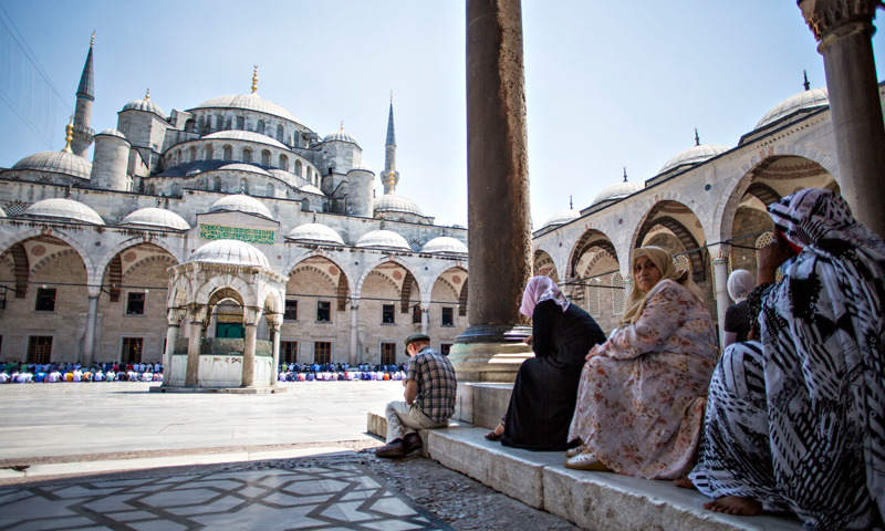 Muslims sit on stairs offering their first Friday prayer during Ramadan at the courtyard of Sultan Ahmet Mosque, also known as the Blue Mosque, in Istanbul, Turkey. — AP Photo