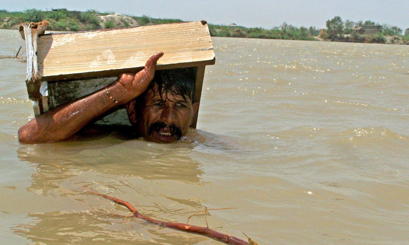 A man wades through chin deep water in Hyderabad after rains caused heavy flooding in the area. INP