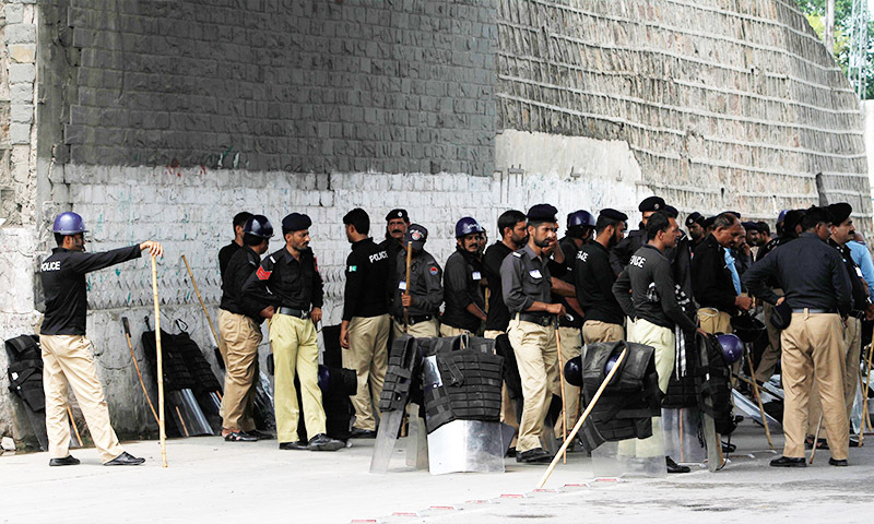 Policemen stand guard on a major highway in Rawalpindi August 14, 2014. - Reuters