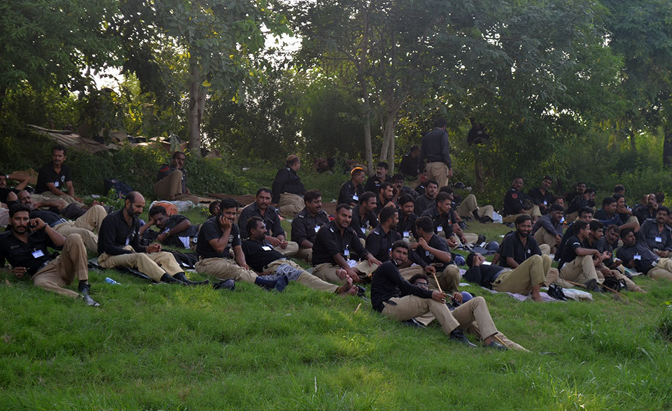 Police personnel on security duty take a rest on the grass near Faizabad Interchange as they wait for the 'Azadi' march to reach Islamabad.—Photo by Irfan Haider