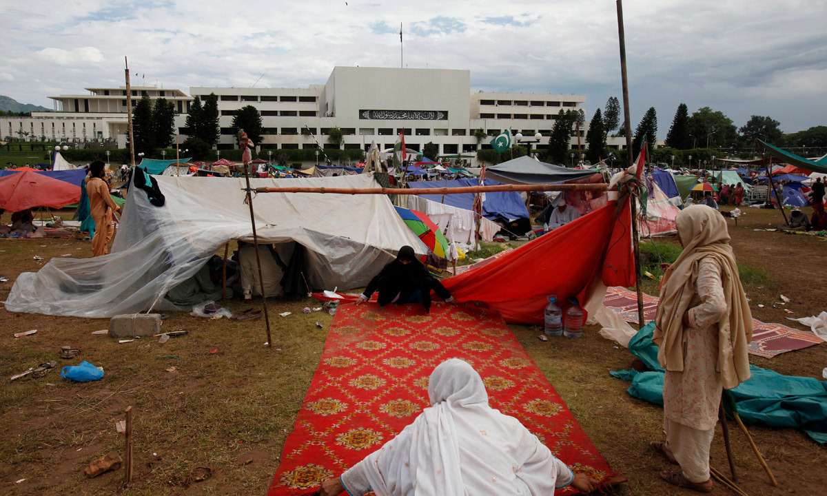 Women supporters of Tahirul Qadri arrange their makeshift camp in front of the parliament building in Islamabad. - Photo by AP