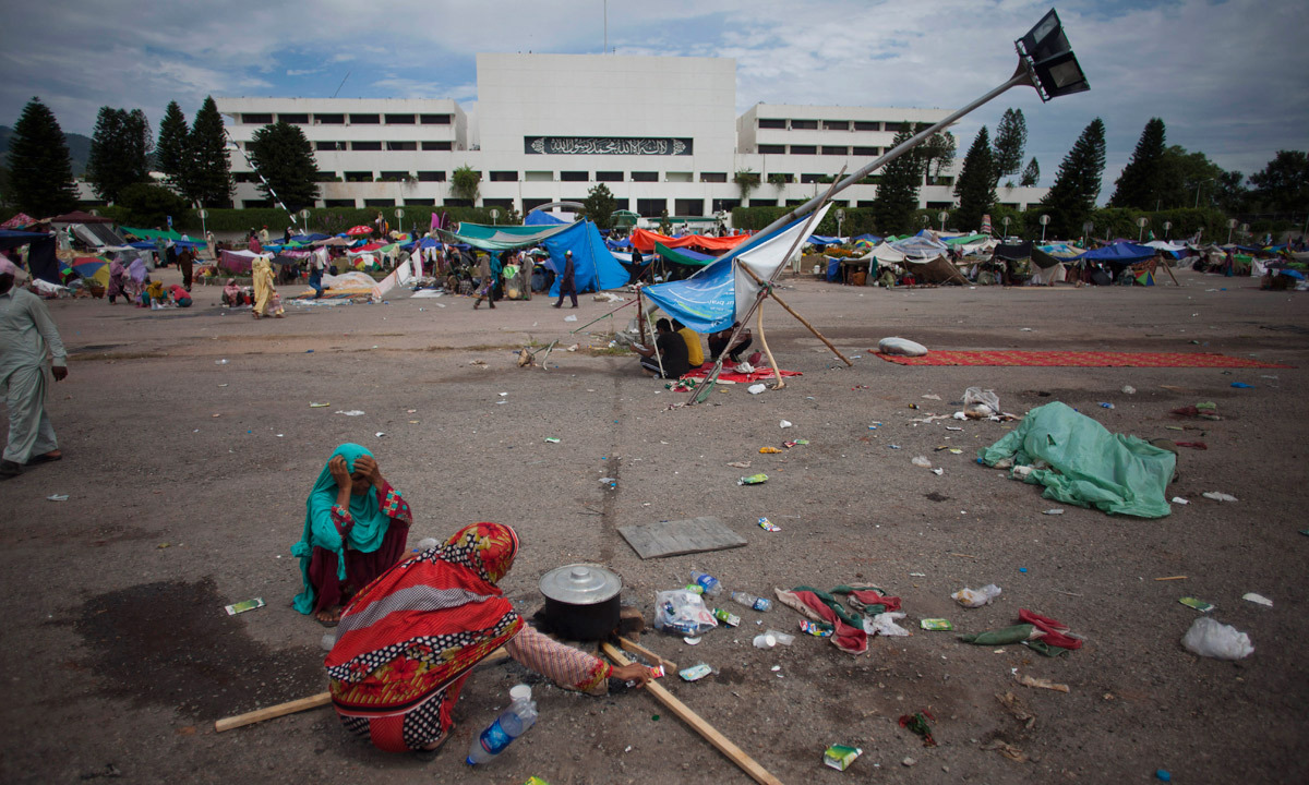 Supporters of Tahirul Qadri cook food in front of the parliament building where they have camped in Islamabad. - Photo by AP