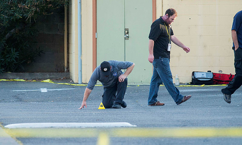 Police officers examine a Motel 6 parking lot where Sheriff's Deputy Danny Oliver was killed in Sacramento, California October 24, 2014. — Photo by Reuters