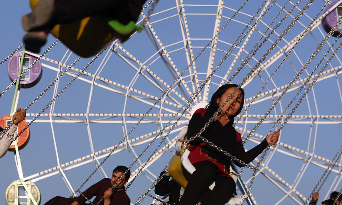 Visitors enjoy a spinning chair ride at Afghanistan's first amusement park called City Park in Kabul. — AP
