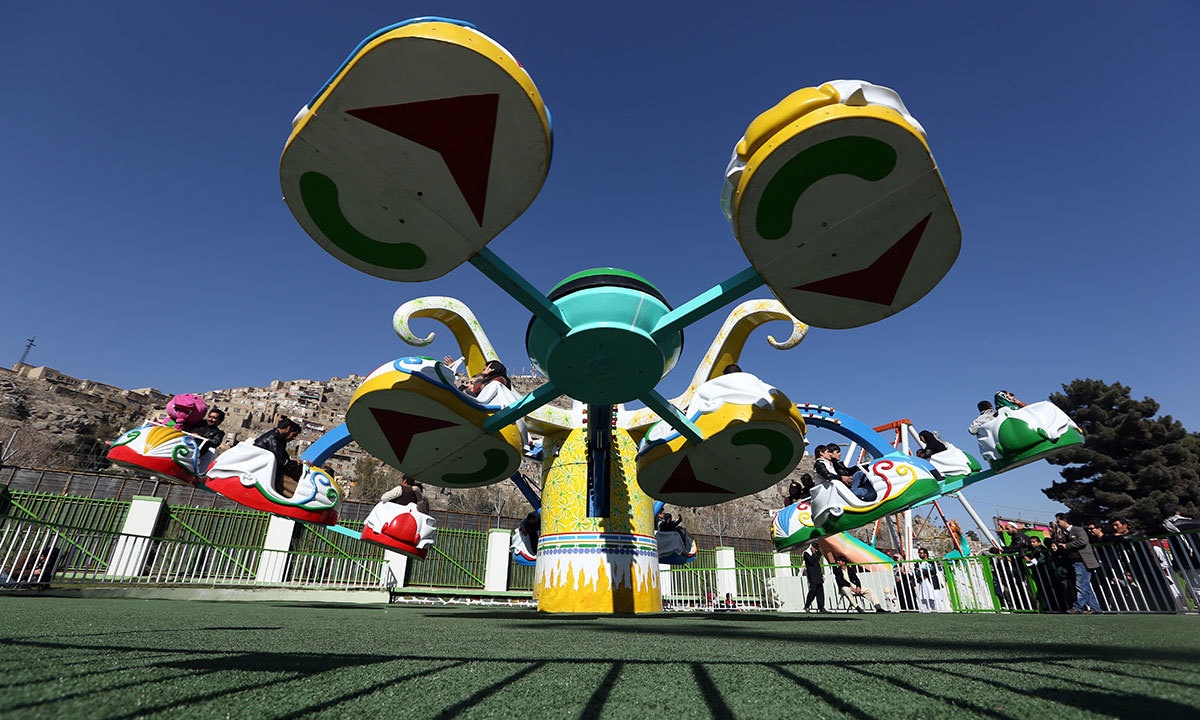 Visitors enjoy a flying spinning saucer ride at Afghanistan's first amusement park called City Park in Kabul. — AP