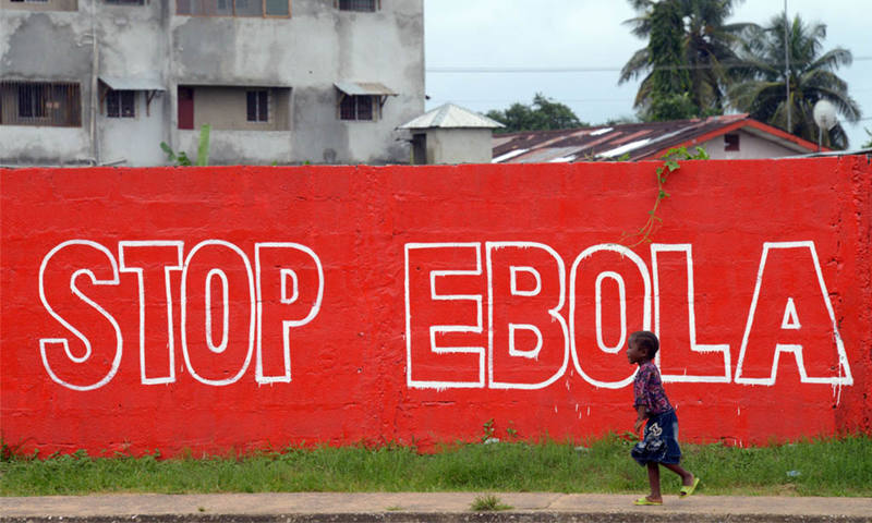 A girl walks past a slogan painted on a wall reading "Stop Ebola" in Monrovia, Liberia – AFP/ File A girl walks past a slogan painted on a wall reading "Stop Ebola" in Monrovia, Liberia – AFP/ File