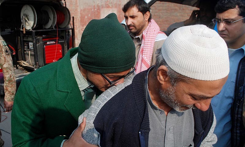 A student cries on a man's shoulder, after he was rescued from the Army Public School - Reuters
