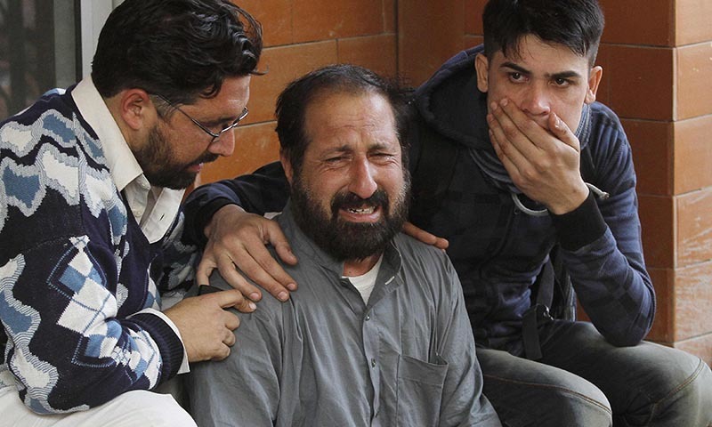 Relatives of a student comfort each other outside Lady Reading Hospital in Peshawar — Reuters