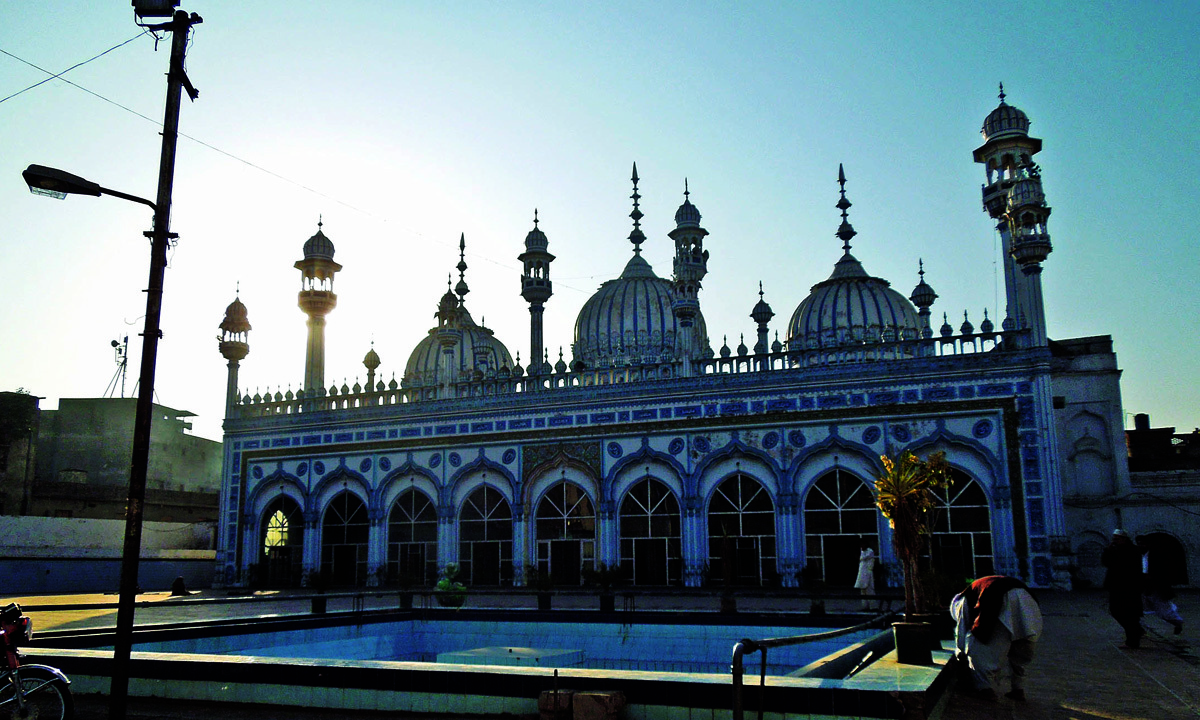 The main building of the mosque with three domes and several small minarets reflective of local aesthetic