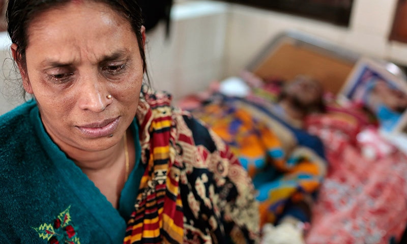 China Karmakar, mother of Rajib Karmakar, a victim of a recent bomb attack, cries as her son receives treatment at a medical college hospital during the ongoing nationwide blockade called by the opposition BNP, in Dhaka, Bangladesh, Friday, Jan 23, 2015. — AP